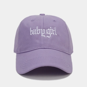 Detailed view of white gothic Babygirl embroidery on a purple cotton baseball cap