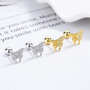Macro shot of butterfly stud earrings in silver and gold with sparkling marquise zirconia