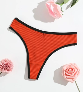 Close-up of ribbed texture and black piping on orange red thong underwear for women