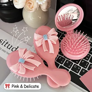 Pink bow air cushion hairbrush set and folding mirror comb on a stylish desk setup