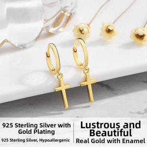 Detailed macro of 18k gold plated 925 sterling silver hoop earrings with cross pendants