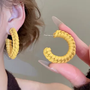 Handwoven bright yellow C-shape hoop earrings with silver pins for a trendy minimalist look