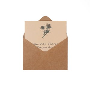 Vintage kraft envelope and floral greeting card with inspirational quote on white background