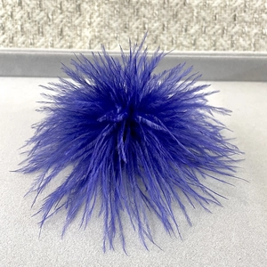 Macro detail of deep blue ostrich feather brooch with fine fluffy texture and vibrant core