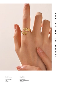 Detail of adjustable golden leaf feather ring with textured finish on a model hand