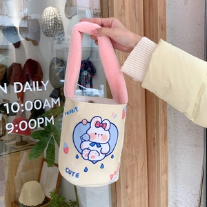 Dettaglio della borsa a secchiello in tela con manico in peluche rosa e stampa coniglietto