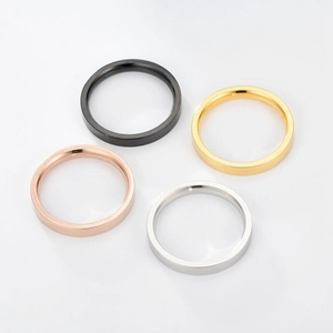 Detailed view of four 3mm minimalist titanium steel rings in black, gold, and silver finishes