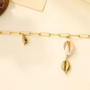 Detailed close-up of a double-layered gold chain necklace with natural shell pendants