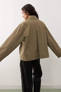 Rear view of a loose-fit olive green cotton jacket with a minimalist solid color design