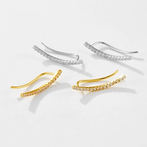 Macro shot of sparkling zircon ear cuffs in silver and gold minimalist finishes
