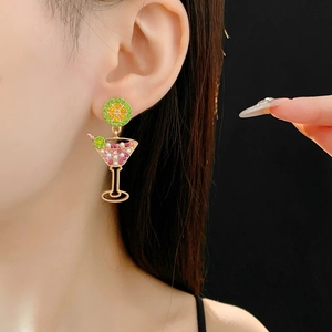 Detail of vintage lime cocktail glass earrings with crystals and white pearls on a model