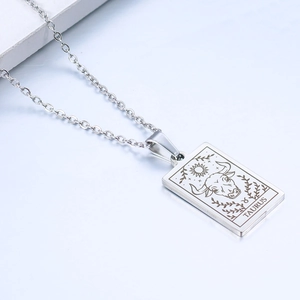 Macro shot of Taurus zodiac pendant with engraved bull symbol and text on rectangular tag
