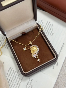 Macro view of 18k gold plated unicorn pendant with cubic zirconia on jewelry box