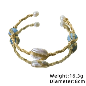 Handmade gold wire wrap bracelet with baroque pearls and blue turquoise beads on white background