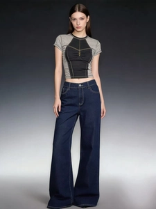 Detailed shot of high waist wide leg denim trousers with vintage wash and contrast stitching