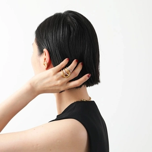 Two-tone stainless steel multi-layered rings and gold ear cuff set on a model
