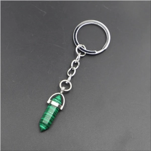 Macro detail of a hexagonal green malachite stone pendant on a silver metal keychain