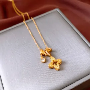 18k gold plated flower necklace with zircon pendants on a gray velvet jewelry box