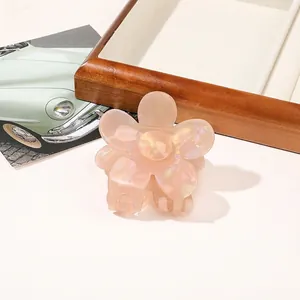 Detailed view of a light pink floral hair claw clip with pearlescent marble texture
