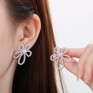 Detail of elegant pearl petal earrings showing five small pearls surrounding a large center