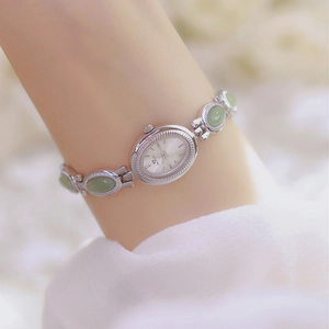 Detail of silver ladies' watch with light green jade stones on an oval link bracelet
