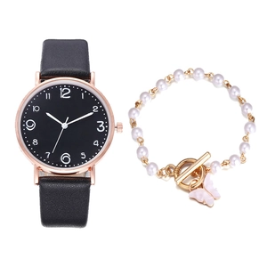 Elegant rose gold watch with black dial paired with a pearl butterfly charm bracelet