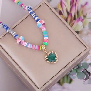 Bohemian colorful polymer clay bead necklace with a green faceted heart pendant