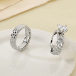 Detail of 18K gold plated stainless steel wedding ring set with 6mm zircon stone on porcelain