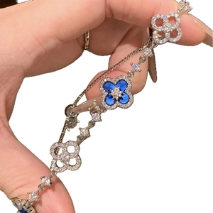 Elegant silver zircon bracelet featuring blue enamel flower and hollow diamond-set charms