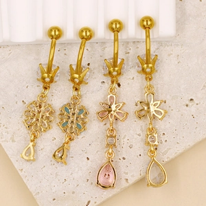 Vue macro de piercings de nombril dorés avec pendentifs fleurs en zircon rose et bleu