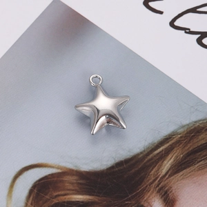 Close-up of a minimalist silver star-shaped metal pendant with a polished smooth finish