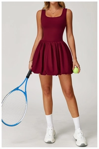 Detail of wine red tennis dress featuring sleeveless deep U-neck and pleated skirt hemline