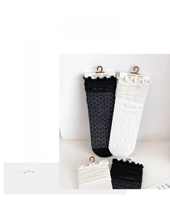 Detail der Spitzen-Hohlstruktur an schwarz-weißen Socken im Ballett-Stil
