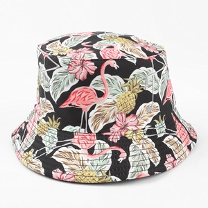 Détail d'un chapeau de soleil tropical avec imprimés flamant, ananas et fleurs sur toile noire
