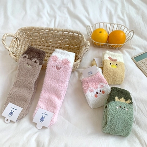 Close-up of fluffy coral fleece socks with cute 3D cartoon animal embroidery details