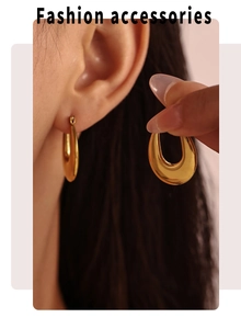 Detail showing 18K gold-plated U-shaped earrings on model for fashion look