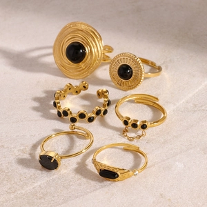 Close-up of vintage gold bohemian ring set with black stones on natural stone background