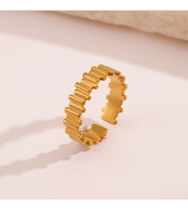 Gros plan d'une bague ajustable dorée avec texture ondulée et finition en métal poli