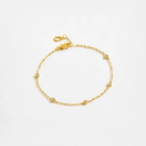 Detailed view of a gold S925 silver bracelet featuring six sparkling round-cut crystals