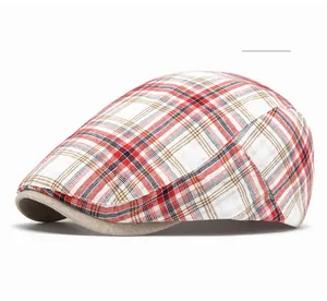 Detailed close-up of vintage red plaid newsboy cap with solid beige visor brim