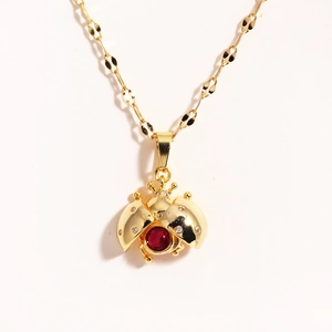 Golden enamel ladybug pendant necklace with red and clear crystals on a delicate O-chain