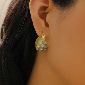 Close-up of vintage flower pearl earrings with gold floral details and zircon stones