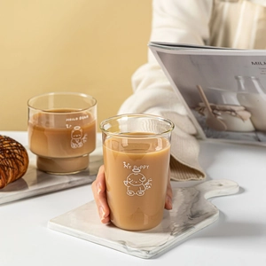 Cute cartoon glass coffee mugs with white puppy and bear prints in a warm setting