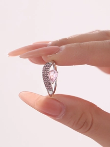 Dettaglio dell'anello con cristallo rosa a cuore su fascia asimmetrica in argento con pietre pavé