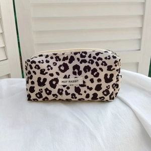 Detail of the leopard print corduroy pouch showing high-quality canvas and label