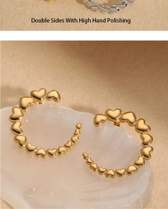 Detail of high hand-polished C-shaped heart earrings on white mineral stone