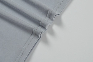 Détail de la robe en maille bleu clair montrant la double couture et la texture du tissu fin