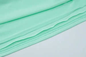 Close-up of mint green knitted fabric showing high-density stitching and texture detail