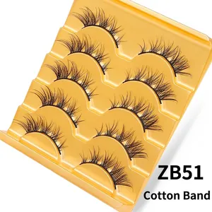 Detail view of 5 pairs of layered fox-eye false eyelashes on a gold wavy tray