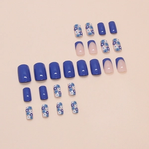 Faux ongles bleus style français avec motifs floraux et couleurs unies sur fond rose